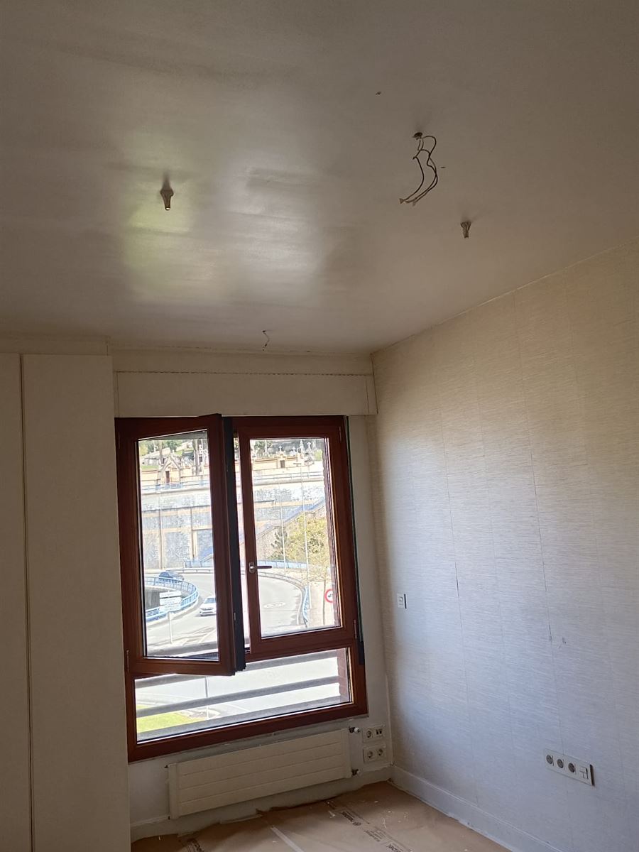 Habitación durante el trabajo, con el suelo protegido con papel y el techo sin terminar