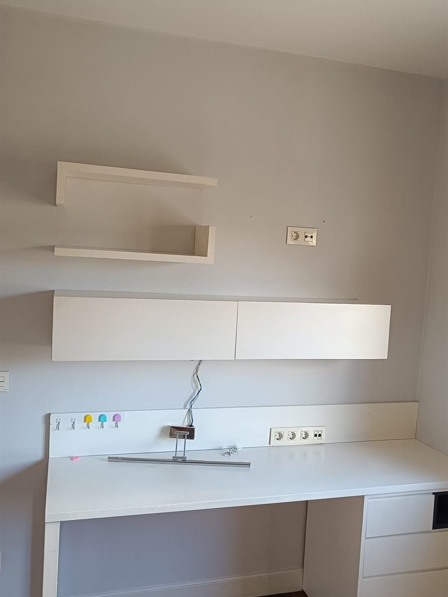 Zona de estudio con escritorio blanco y pared gris claro